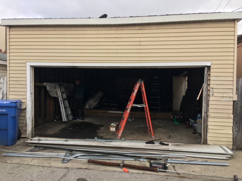 Open garage door frame with ladder during door replacement, photo 2